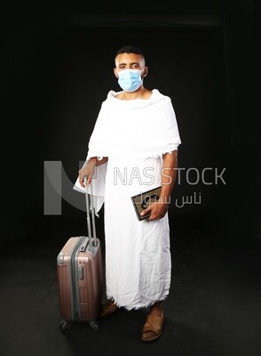 A man wearing an ihram dress prays