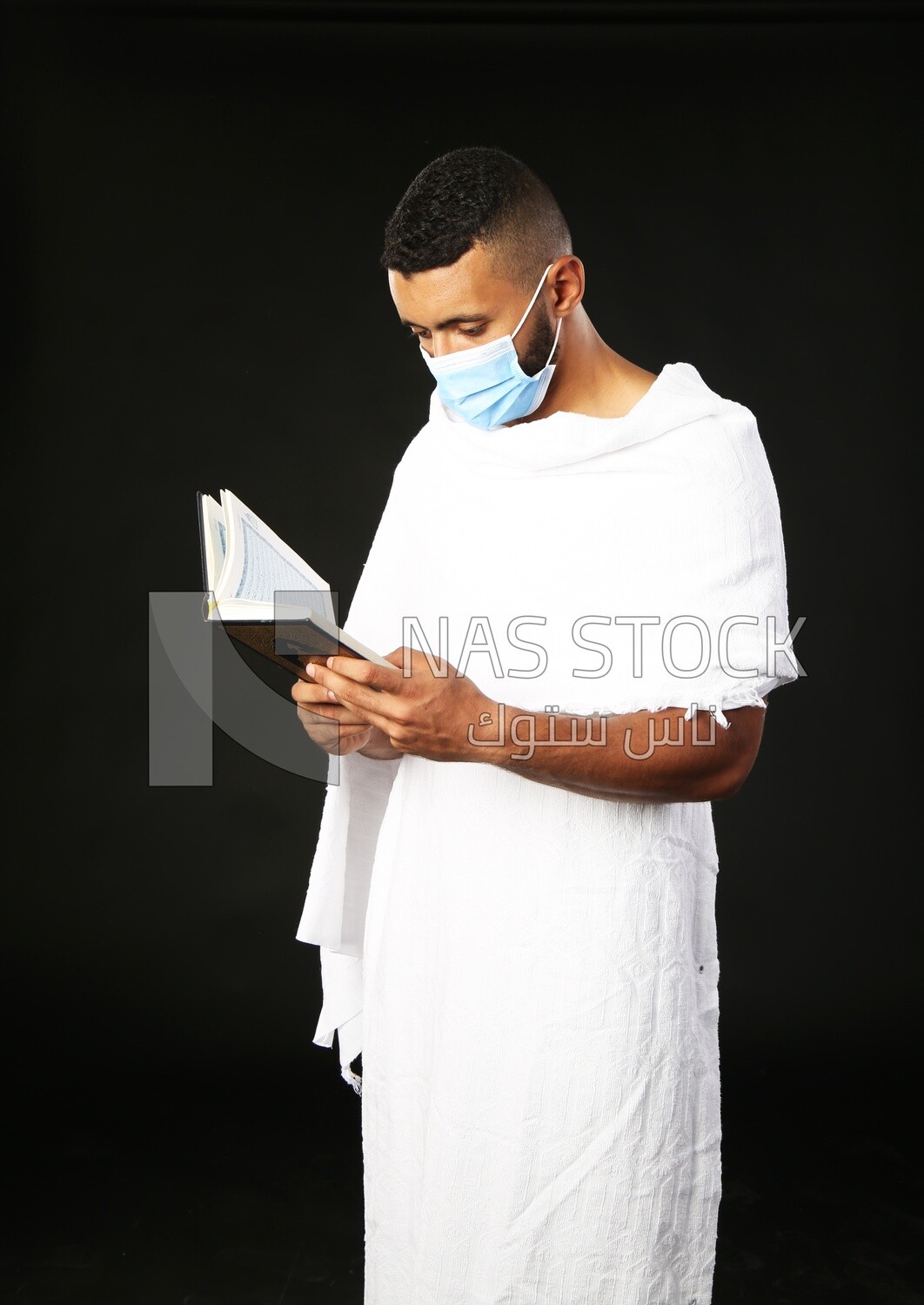 A man wearing an ihram dress prays