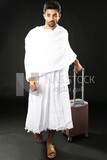 A man wearing an ihram dress with his luggage