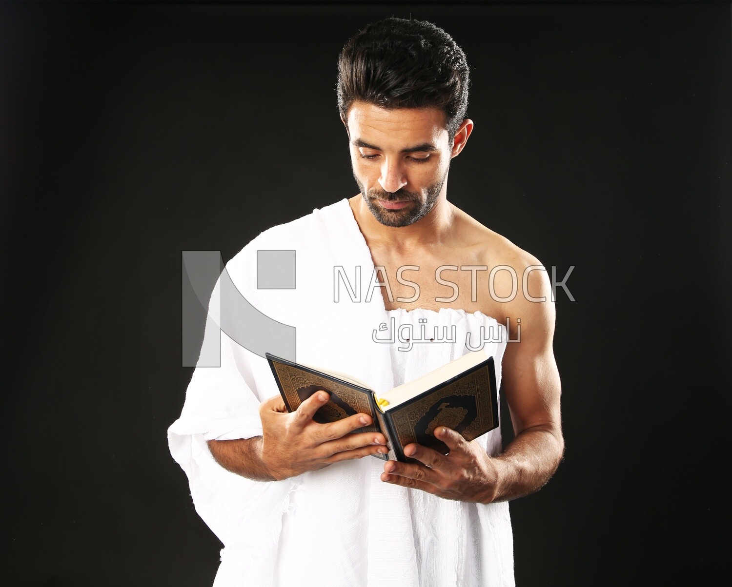 A man wearing an ihram dress prays