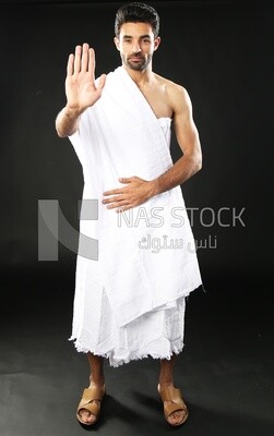 A man wearing an ihram dress with stop sign​