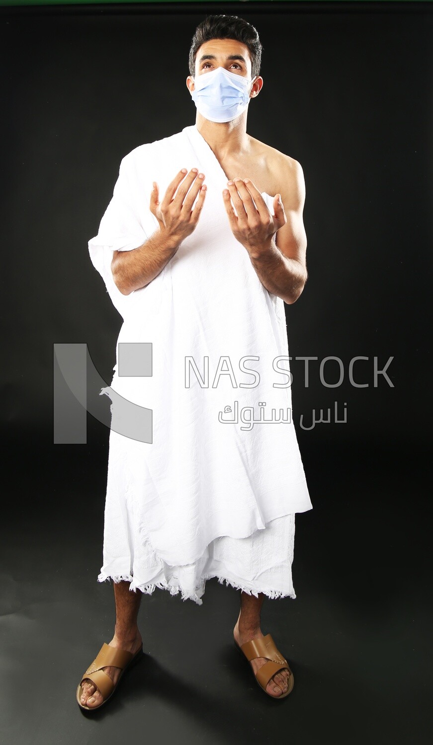 A man wearing an ihram dress with a mask