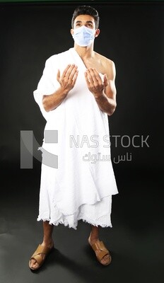 A man wearing an ihram dress with a mask