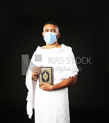 A man wearing an ihram dress prays