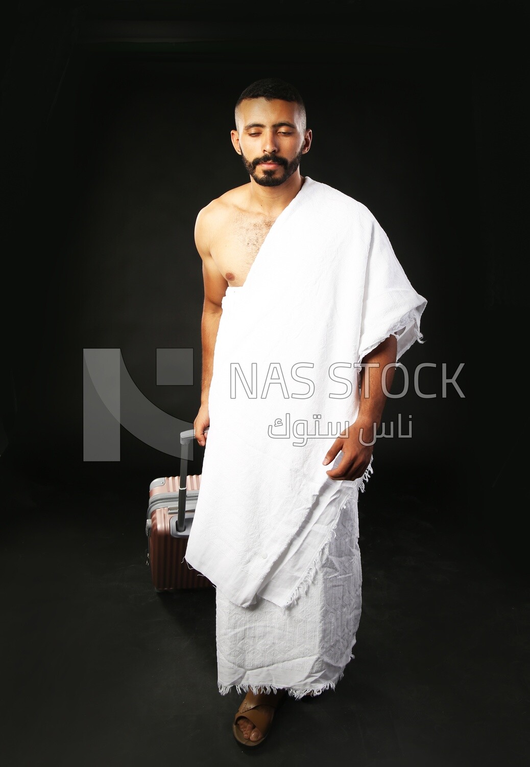 A man wearing an ihram dress with his luggage
