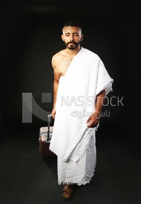 A man wearing an ihram dress with his luggage