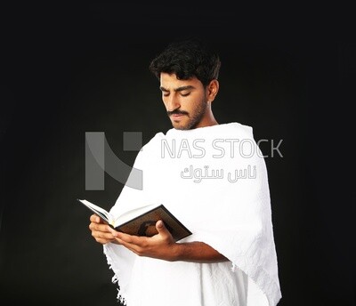 A man wearing an ihram dress prays