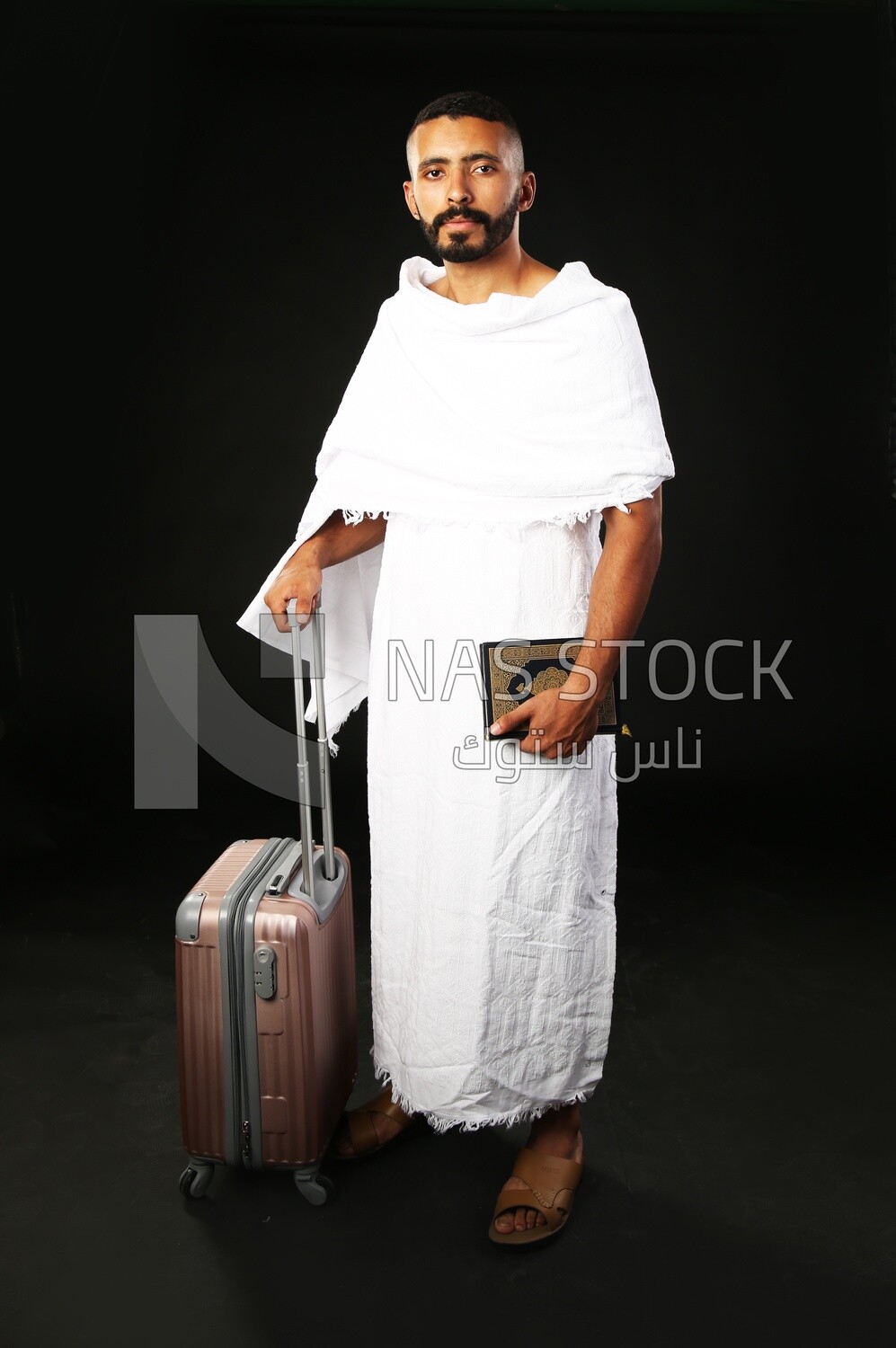 A man wearing an ihram dress prays