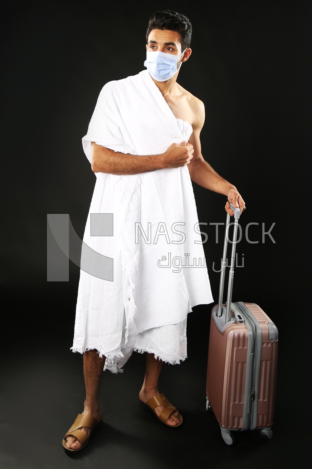 A man wearing an ihram dress with his luggage