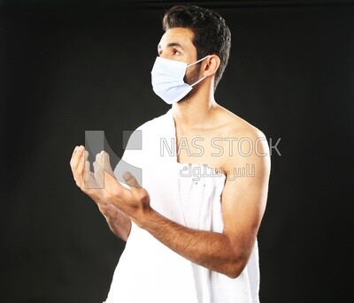A man wearing an ihram dress with a mask