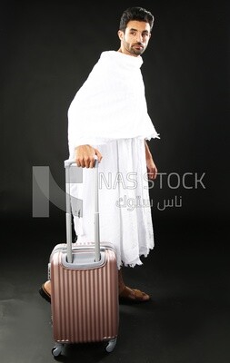 A man wearing an ihram dress with his luggage