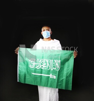 A man wearing an ihram dress with a mask