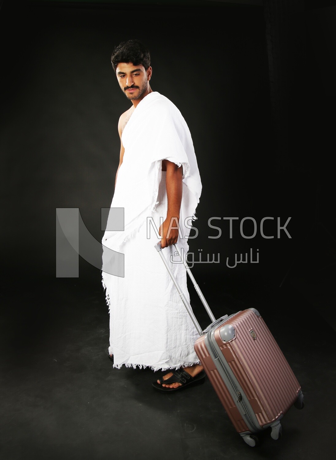 A man wearing an ihram dress with his luggage