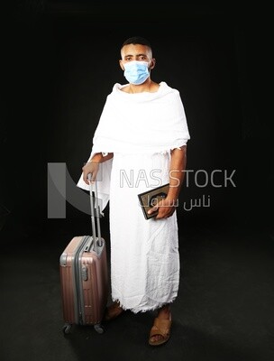 A man wearing an ihram dress prays