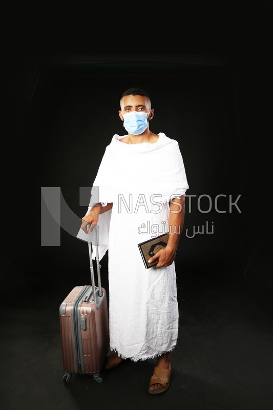 A man wearing an ihram dress prays