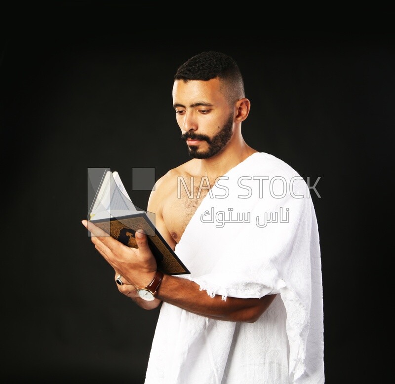 A man wearing an ihram dress prays