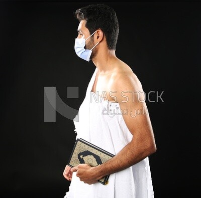 A man wearing an ihram dress prays