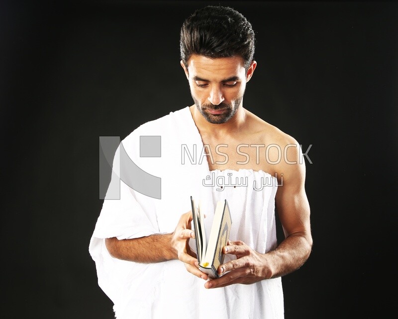 A man wearing an ihram dress prays