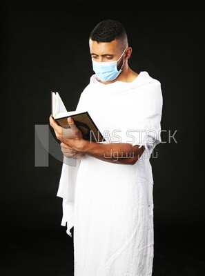 A man wearing an ihram dress prays