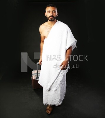 A man wearing an ihram dress with his luggage