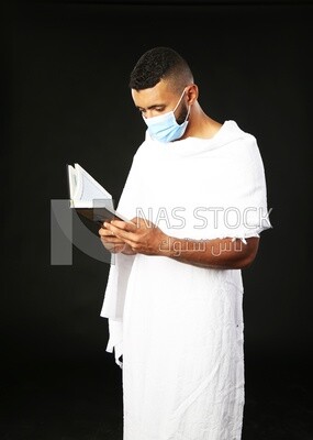 A man wearing an ihram dress prays