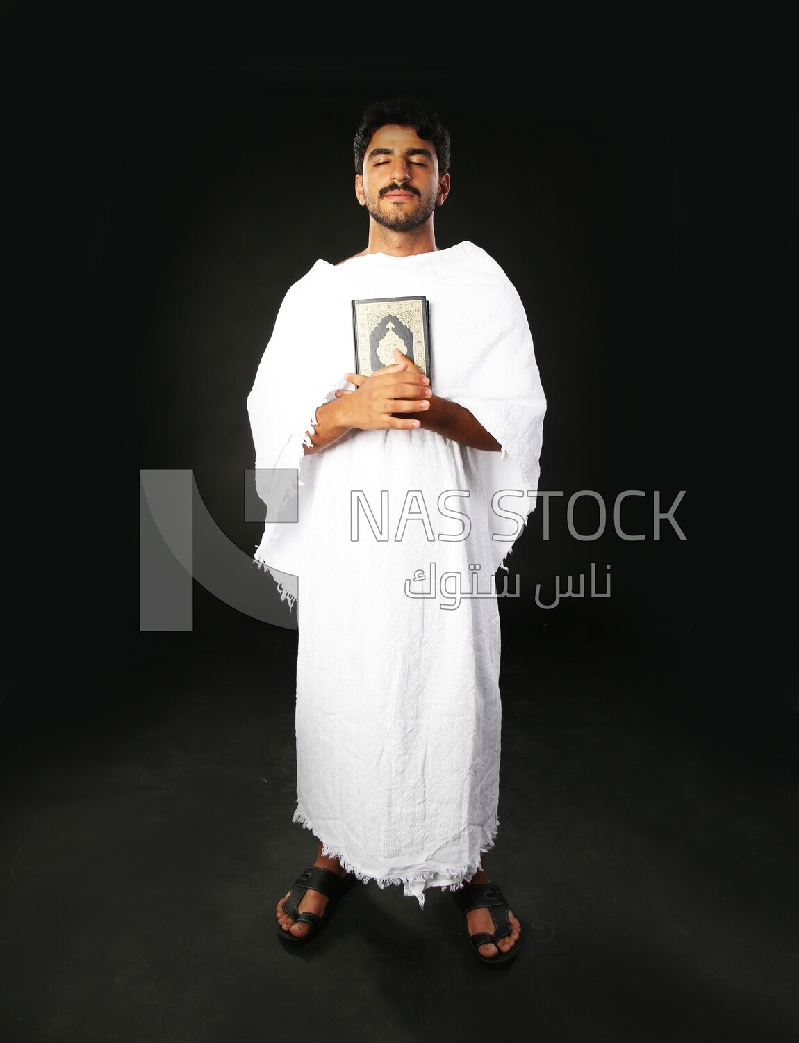 A man wearing an ihram dress prays