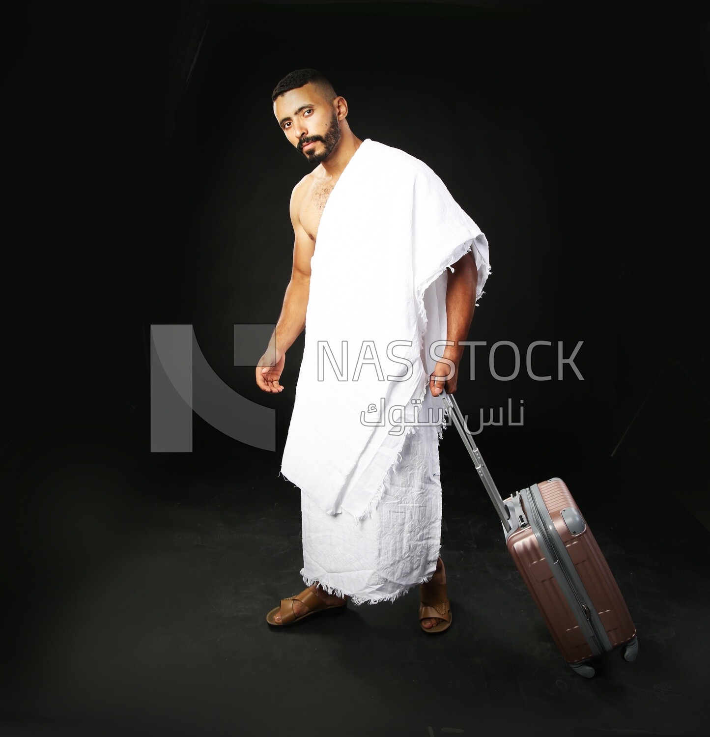 A man wearing an ihram dress with his luggage