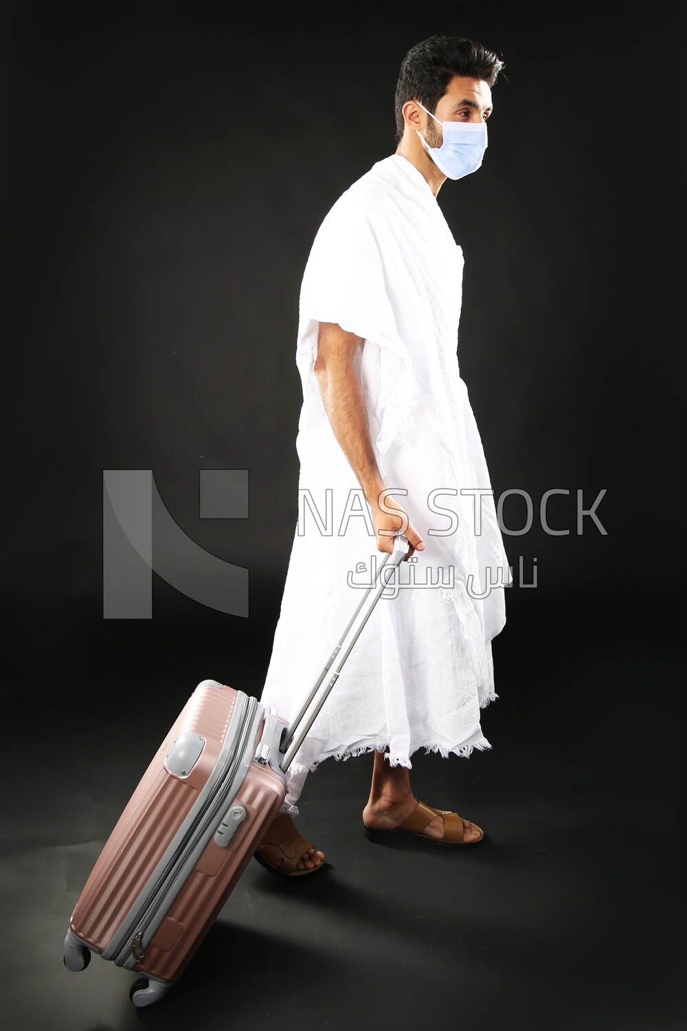 A man wearing an ihram dress with his luggage
