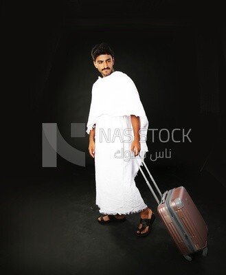 A man wearing an ihram dress with his luggage