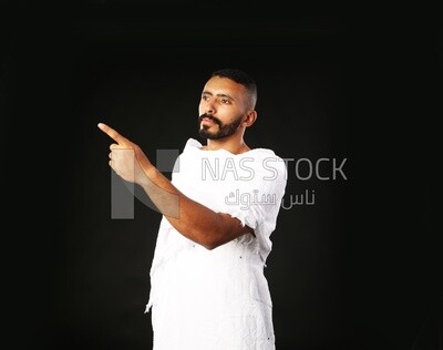 A man wearing an ihram dress pointing away
