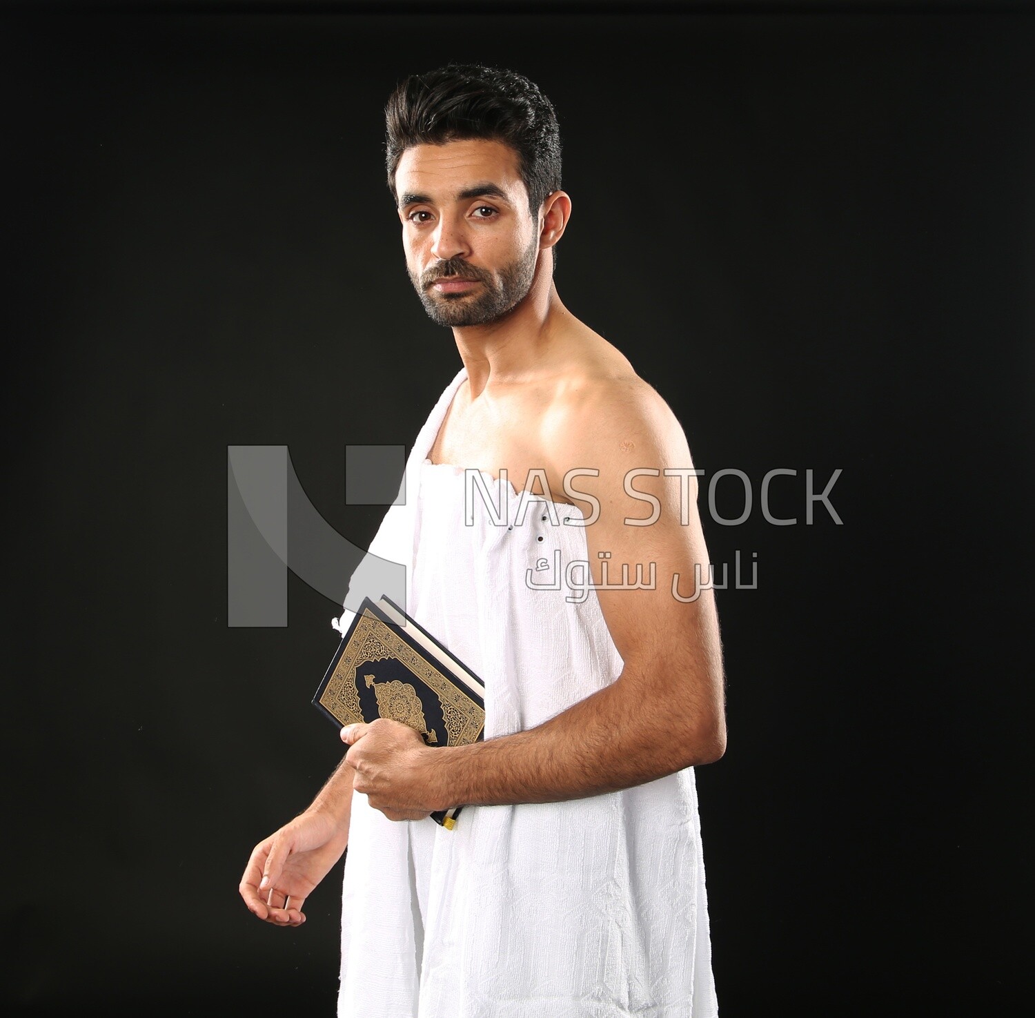 A man wearing an ihram dress prays