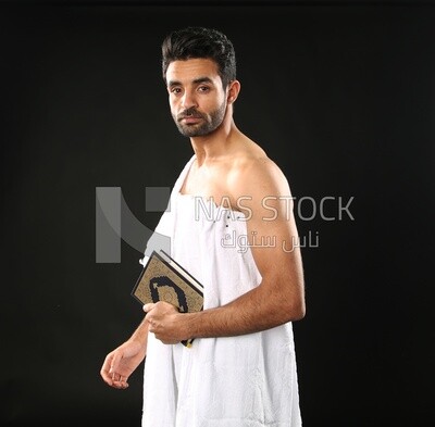 A man wearing an ihram dress prays