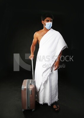 A man wearing an ihram dress with his luggage
