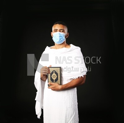 A man wearing an ihram dress prays