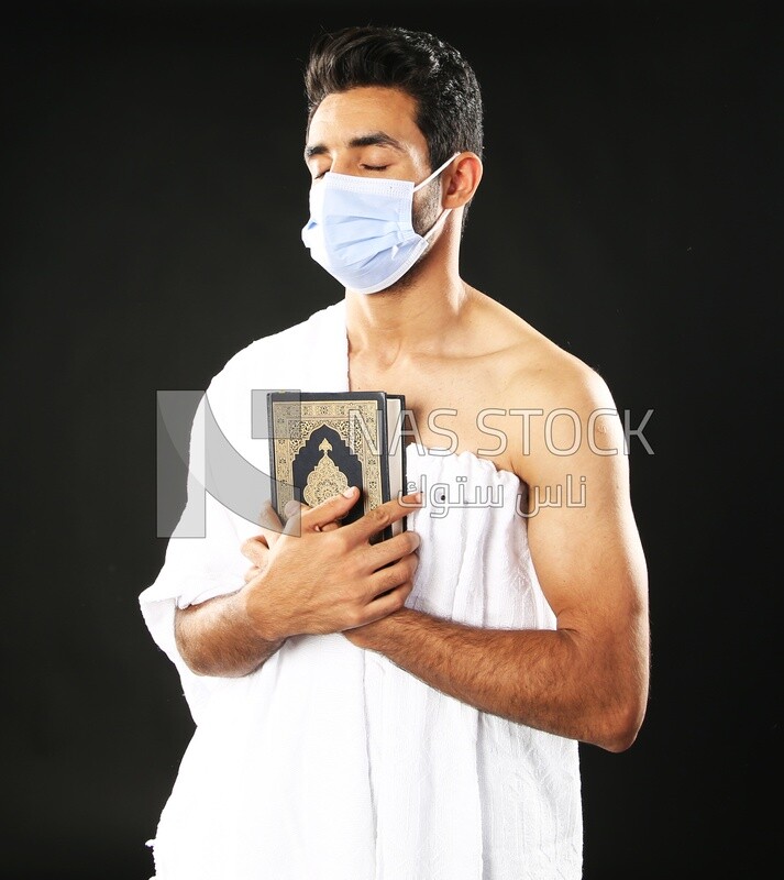 A man wearing an ihram dress prays