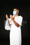 A man wearing an ihram dress with a mask