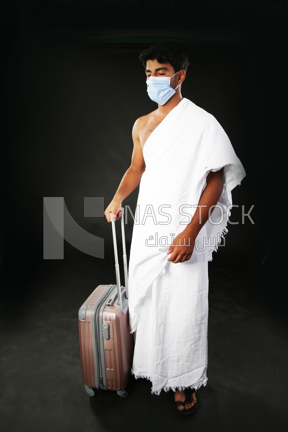 A man wearing an ihram dress with his luggage