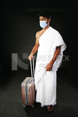 A man wearing an ihram dress with his luggage