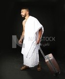 A man wearing an ihram dress with his luggage