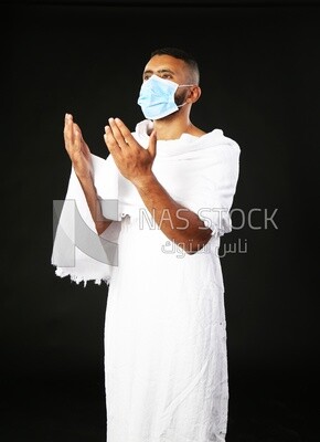 A man wearing an ihram dress with a mask