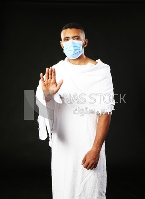 A man wearing an ihram dress with stop sign​