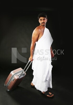 A man wearing an ihram dress with his luggage