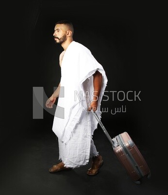 A man wearing an ihram dress with his luggage