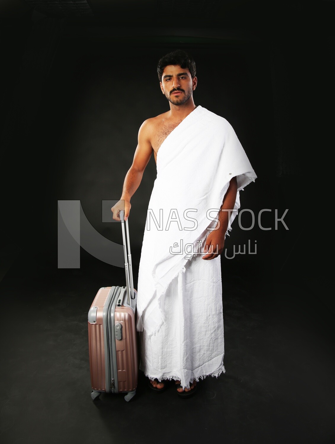 A man wearing an ihram dress with his luggage