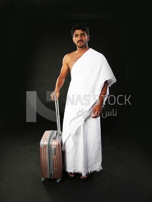 A man wearing an ihram dress with his luggage