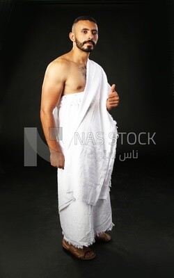 A man wearing an ihram dress doing an okay sign