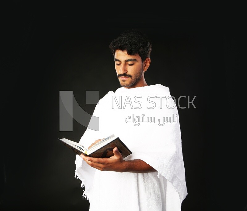 A man wearing an ihram dress prays