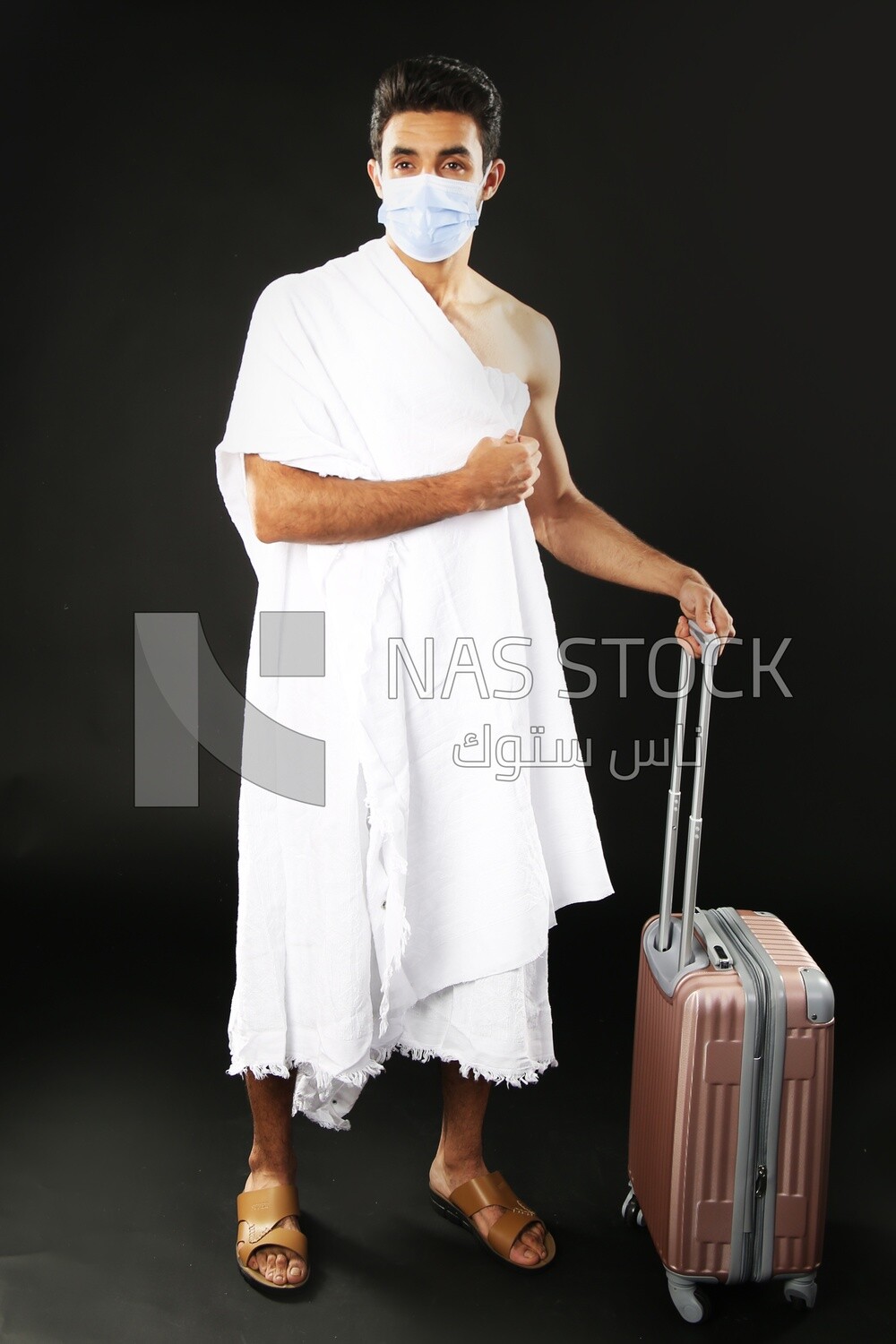 A man wearing an ihram dress with his luggage