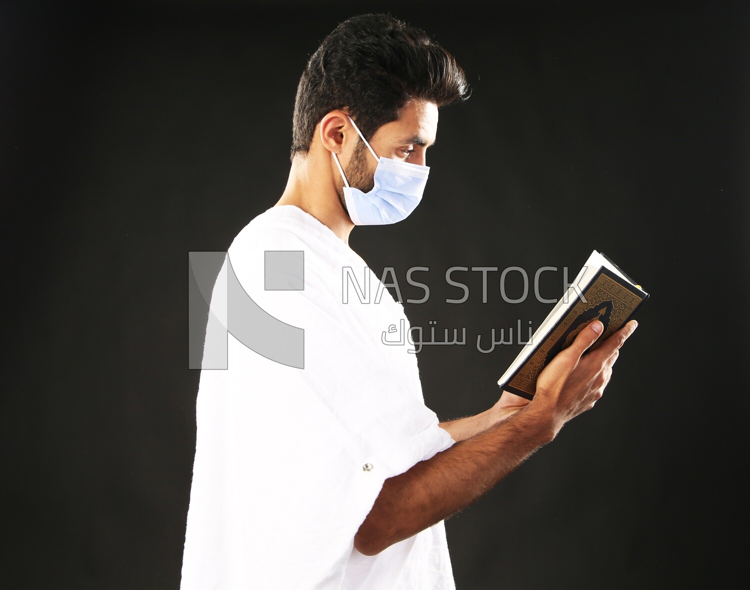 A man wearing an ihram dress prays