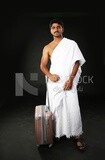 A man wearing an ihram dress with his luggage